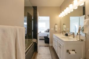 a bathroom with a sink and a shower and a bed at Toroweap-4bed,3bath,hot tub,deck in Hildale