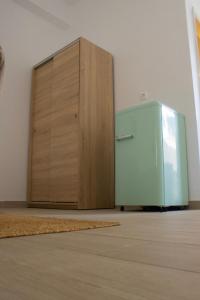 a green refrigerator sitting in the corner of a room at Amelia rooms in Batsi