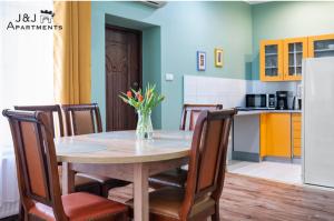 a dining room table with chairs and a vase of flowers at J&J Apartments Łazienna 30 Apartament 10-5 in Toruń