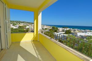 a yellow balcony with a view of the ocean at B&B Lu Cantoru in Marina di Pescoluse