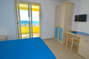 a room with a blue bed and a view of the ocean at B&B Lu Cantoru in Marina di Pescoluse