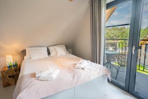 sypialnia z łóżkiem i dużym oknem w obiekcie Palmowe Wzgórze Skoszewo - Domek Górny w mieście Skoszewo