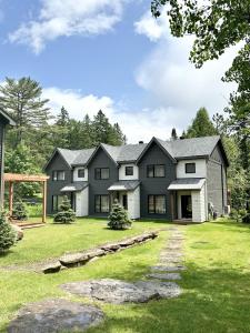 una gran casa negra con un patio de césped en Condos Kamik Tremblant, en Mont-Tremblant