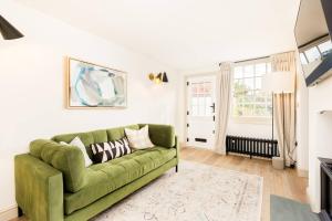 a green couch in a living room with a window at Pass the Keys Central Stratford upon Avon Super Stylish 1Bed in Stratford-upon-Avon