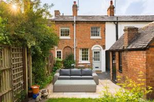 a patio with a couch in front of a house at Pass the Keys Central Stratford upon Avon Super Stylish 1Bed in Stratford-upon-Avon