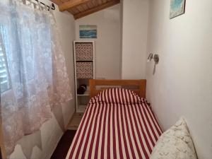 ein kleines Schlafzimmer mit einem Bett und einem Fenster in der Unterkunft Casa Battiscuro - for Adventurers only in Plomin