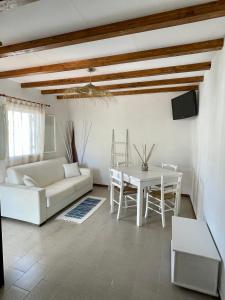 ein Wohnzimmer mit einem weißen Sofa und einem Tisch in der Unterkunft White House Salento in Sant'Isidoro