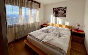 una camera da letto con un letto con lenzuola bianche e una finestra di B&B CHALET NICOLUSSI a Trento