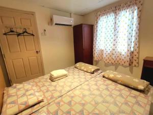 a bedroom with a bed with two pillows and a window at Pangkor Coral Bay Homestay 315 in Pangkor