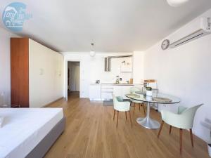 a bedroom with a table and chairs and a kitchen at Verdemare 309 Tirabora Short Rent in Trieste