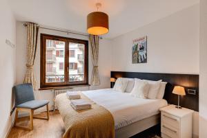 シャモニー・モンブランにあるAPARTMENT COSMIQUES - Alpes Travel - Central Chamonix - Sleeps 4のベッドルーム1室(大型ベッド1台、椅子、窓付)