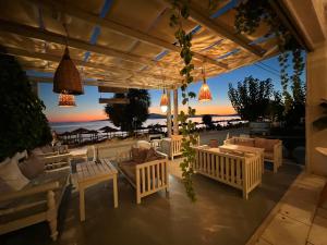 a patio with a view of the beach at sunset at Manios Suites in Agia Anna Naxos