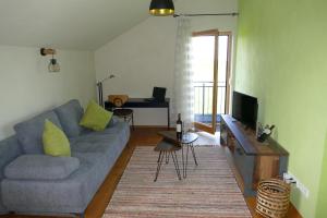 uma sala de estar com um sofá azul e uma televisão em Ferienwohnung Abendsonne em Oy-Mittelberg