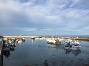 un groupe de bateaux est amarré dans un port dans l'établissement Le Grand Hôtel de la Marine, à Port-en-Bessin-Huppain