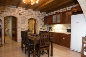 a kitchen with a table and a white refrigerator at Villas Alexandros Petrino in Kalamaki Heraklion