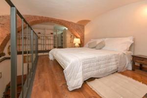 ein Schlafzimmer mit einem weißen Bett und einer Treppe in der Unterkunft Loft Principe Tommaso - San Salvario. in Turin