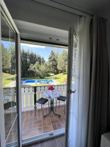 una puerta corredera de cristal que da a un patio con mesa y sillas en Apartments Roemerschlucht, en Velden am Wörthersee