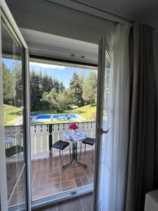 a sliding glass door leading to a patio with a table and chairs at Apartments Roemerschlucht in Velden am Wörthersee