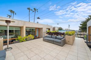 an outdoor patio with a couch and some plants at 14 West Boutique Hotel in Laguna Beach