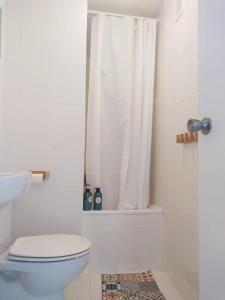 a bathroom with a toilet and a shower curtain at Un lugar llamado descanso in Matalascañas