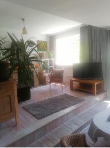 a living room with a flat screen tv and a couch at Przytulny dom z ogrodem i tarasem in Koszalin