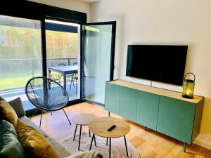 a living room with a tv and a couch and a table at Nuevo Terraza y parking, 2 hab, 2 baños, 6-7 personas Disponible!! JUN, JUL, AGO, SEPT in Llanes