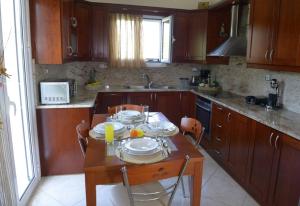 una cocina con una mesa de madera con platos. en SIMOS' sea view house, en Nikópolis