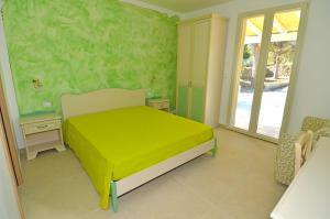 a bedroom with a bed with a green wall at B&B Lu Cantoru in Marina di Pescoluse