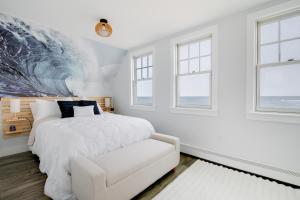 Un dormitorio con una cama blanca y un gran mural de olas. en Beachfront Scituate Home with Beautiful Ocean View, en Scituate