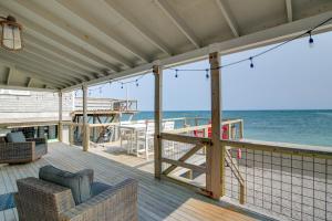 Un porche cubierto con vista al océano. en Beachfront Scituate Home with Beautiful Ocean View, en Scituate