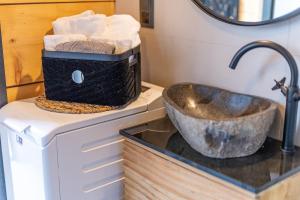 łazienka z umywalką i koszem ręczników w obiekcie Palmowe Wzgórze Skoszewo - Domek Górny w mieście Skoszewo