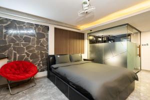 a bedroom with a bed and a red chair at G9 Homestay - Đề Thám in Ho Chi Minh City