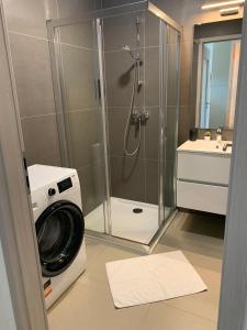 a washing machine in a bathroom with a shower at Római Ház Apartman in Siófok