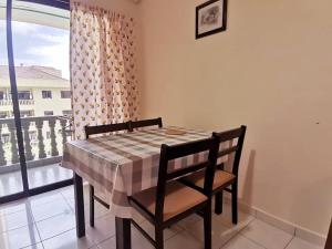 - une table et des chaises dans une chambre avec fenêtre dans l'établissement Pangkor Coral Bay Homestay 315, à Île de Pangkor