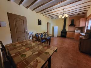 sala de estar con mesa y cocina en Casa rural CASA DEL CERRO, en Casas del Cerro