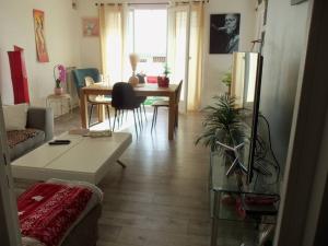 a living room with a couch and a table at Appartement vue mer accès plage in Antibes