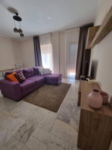 sala de estar con sofá púrpura y TV en Appartamento Sala, en Benevento