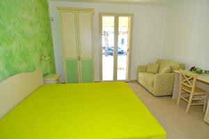 a bedroom with a large yellow bed and a chair at B&B Lu Cantoru in Marina di Pescoluse