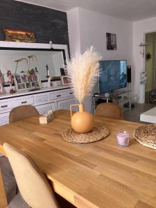 una mesa de comedor con un jarrón con plumas en Appartement vue mer accès plage en Antibes