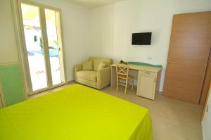 a bedroom with a yellow bed and a chair and a desk at B&B Lu Cantoru in Marina di Pescoluse