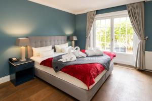 a bedroom with a bed with two stuffed animals on it at Hotel Parkresidenz Christian VIII in Archsum +70 photos
