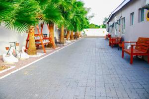 a street with benches and palm trees next to a building at Eagles Nest Self-Catering Apartments in Gaborone