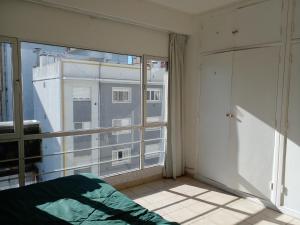1 dormitorio con vistas a un edificio desde una ventana en Calido Monoambiente Zona Shopping Aldrey en Mar del Plata
