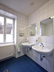 a bathroom with two sinks and a mirror at Youth Hostel Larochette in Larochette