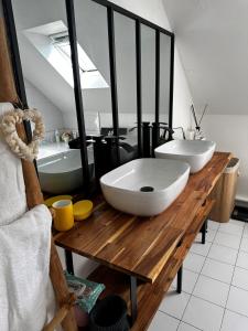 a bathroom with two white sinks on a wooden table at LES TEMPS HEUREUX exclusivement Familles in Quimper