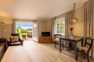 a living room with a table and a couch at Hotel Parkresidenz Christian VIII in Archsum