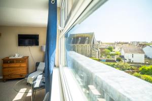 a room with a window with a view of a building at Sleepy Puffin Guest House in Tenby