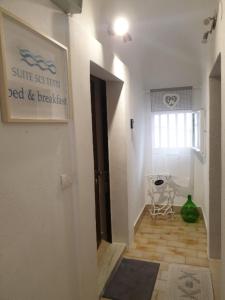a hallway with a table and a chair in a room at Suite Sui Tetti Apartment in Bari