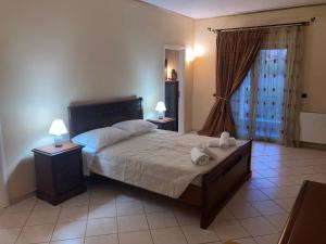 a bedroom with a bed with two night stands and two lamps at VILLA MARIA in Kanálion