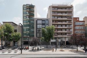 numa I Colmena Apartments في برشلونة: مبنى في مدينة فيها اشجار ومباني